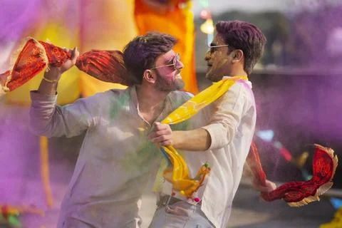 Two young indian men with colored face dancing together during holi color Stock Photos