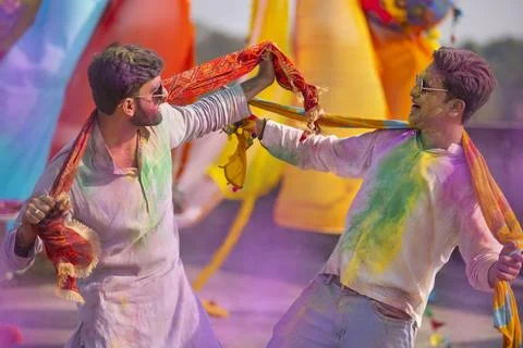 Two young indian men with colored face dancing during holi color festival Stock Photos