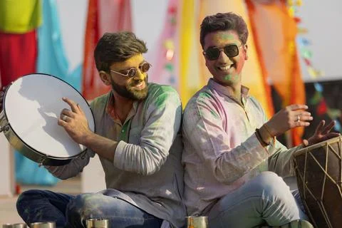Two young indian men with colored face singing during holi color festival Stock Photos