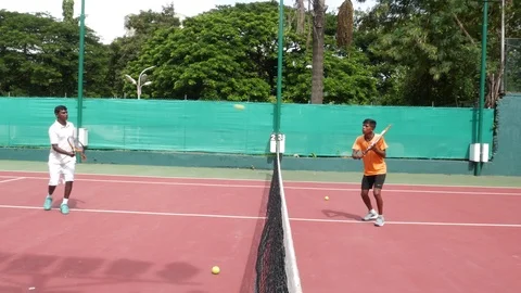 Two YOUNG INDIAN Men PLAYING TENNIS, volleying,   Stock Footage 94370533