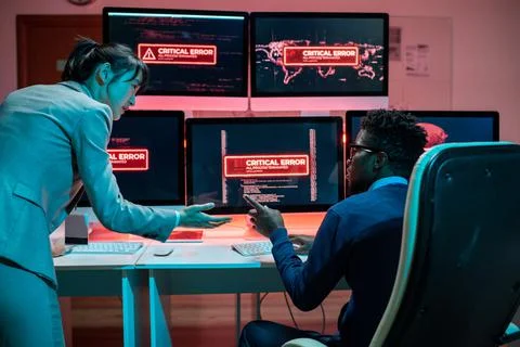 Two young intercultural programmers trying to solve problem with access to data Stock Photos