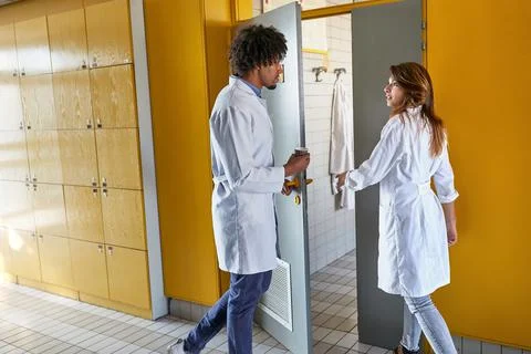 Two young interns entering dressing room Stock Photos