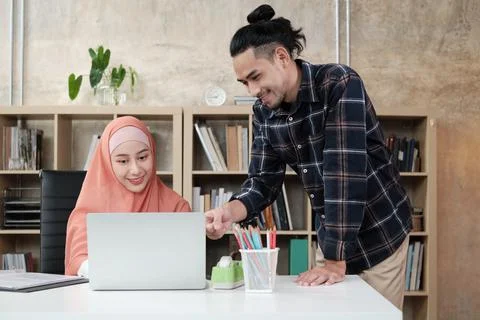 Two young Islamic colleagues work in a small startup office. Stock Photos