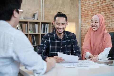 Two young Islamic colleagues work in a small startup office. Фото