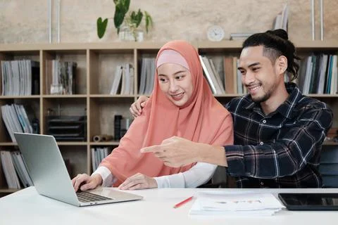 Two young Islamic couples work in a small startup office. Stock Photos