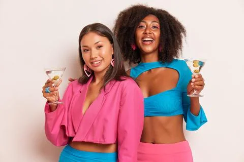 Two young ladies having fun inside studio, black girl in blue top and Asian girl Stock Photos