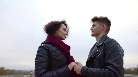 Two young lovers are holding hands and flirting against Eiffel tower in Paris in Stock Footage 98808673