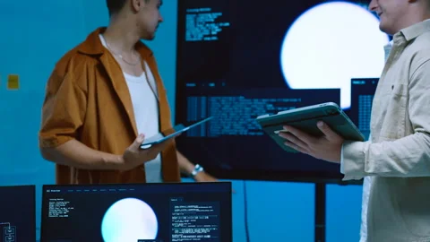 Two young male developers looking at large monitor screen with AI code back.. Stock Footage 337090862