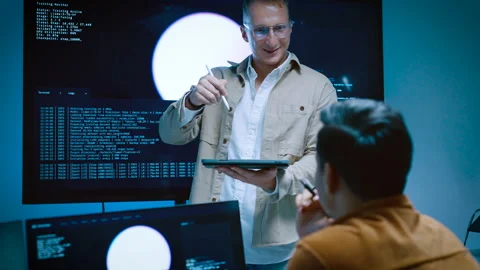 Two young male software developers discussing and planning AI program code .. Stockbeeldmateriaal 337094533