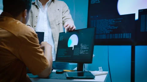 Two young male software developers collaborating on coding project pointing.. Stock Footage 337102618