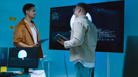 Two young male software engineers standing and analyzing AI program code wo.. Stock Footage 337096758