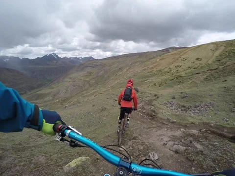 Two Young Males Extreme Mountain biking In An Alpine Landscape With Stormy Skies 스톡 동영상 78250902