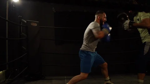 Two young man exercising punches inside a ring in slow motion slider move Stock Footage 101206135