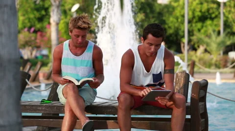 Two young man sitting at the park and relaxing Stock Footage 41335113
