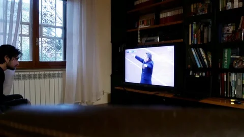 Two young man on a sofa, viewed from rear, watch a football match on a led tv Stock Footage 102232040