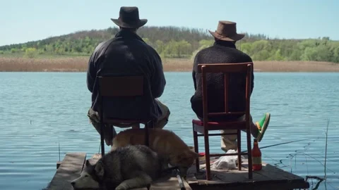Two young men and their dogs fishing from the pier. Stock Footage 241405272