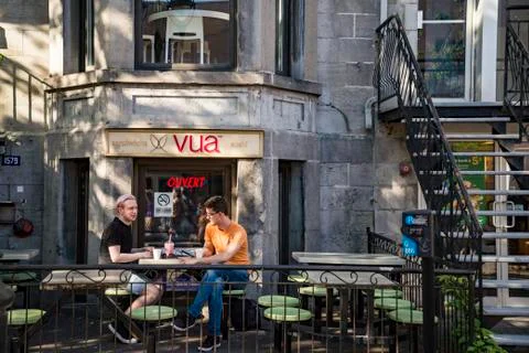 Two young men are drinking in a modern urban cafe. Stock Photos