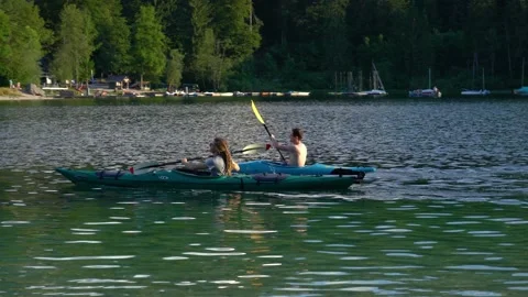 Two young men are paddling in a kayak in Lake Bohinj Stock Footage 228467863