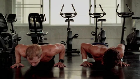 Two young men are pushing up and competing in the gym. Stock Footage 131848988