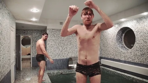 Two Young men are relaxing and jumping, swims in the pool in sauna Stock Footage 73528970