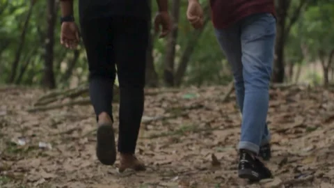 Two young men are walking into the jungle Stock Footage 296525336