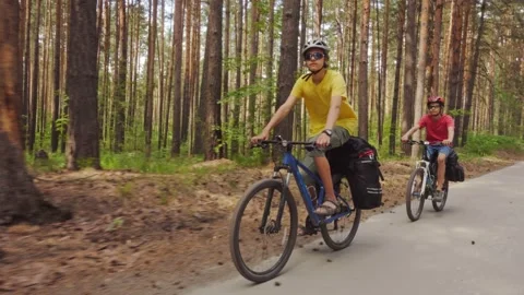 Two young men with backpacks ride bicycles along the road. Stock Footage 158717003