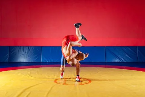 Two young men in blue and red wrestling tights are wrestlng and making a hip  Stock Photos