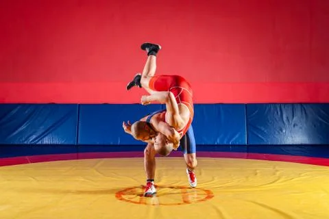 Two young men in blue and red wrestling tights are wrestlng and making a hip  Stock Photos