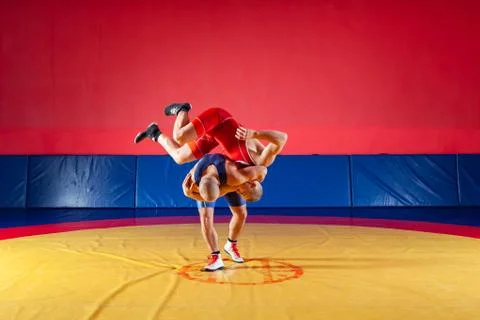 Two young men in blue and red wrestling tights are wrestlng and making a hip  Stock Photos
