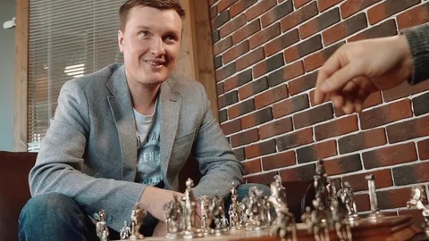 Two young men of a businessman playing chess in the office Stock Footage 72618997