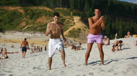 Two young men dancing on beach Stock Footage 769530