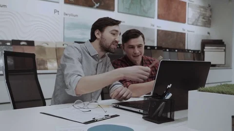 Two young men designers workinh on project in the design studio Stock Footage 84731658