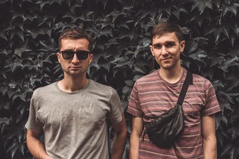 Two young men with different emotions in casual t-shirts, one in black Stock Photos