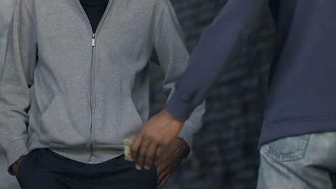 Two young men exchanging drugs for money, illegal trafficking and addiction Video stock 116404423