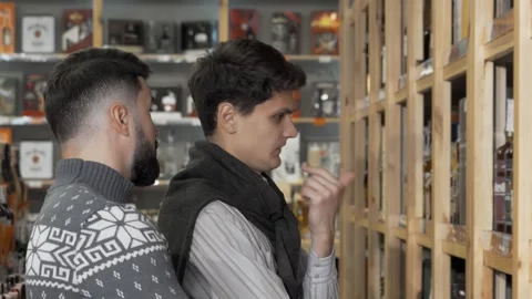 Two young men exploring a vibrant wine market Video stock 311945584