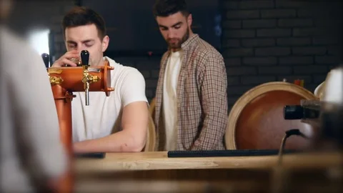 Two young men friends sitting in bar and talking with each other while drinking Stock Footage 83203598