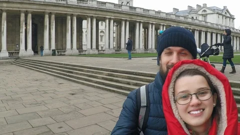 Two young men, a guy and a girl are walking in London near the buildings in a Stock Footage 102808183
