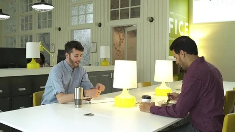 Two young men having lunch in an office 動画素材 83396386