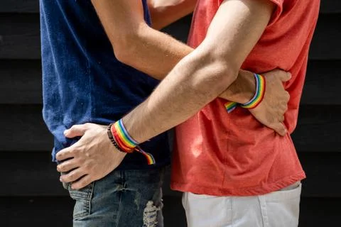 Two young men hugging each other at the waist with bracelets with the lgtb fl Stock Photos