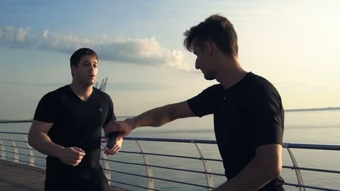 Two young men with knife fight training against sunrise in slow motion Stock Footage 78108329