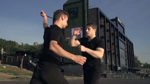 Two young men with knife fight training against sunrise in slow motion Stock Footage 78141664