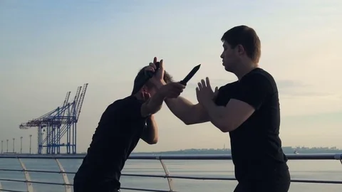 Two young men with knife fight training against sunrise in slow motion Stock Footage 78142610