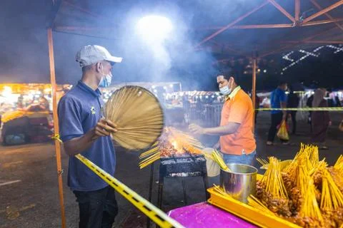 Two young men making satay skewers on an open fire grill. Stock-Fotos