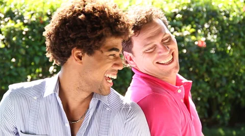 Two young men of mixed race laughing together outdoors Stock Footage 38762376