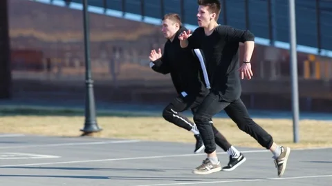 Two young men performing acrobatic parkour tricks. Overcoming obstacles Stock Footage 106860123