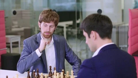 Two young men play chess and the loser throws a board into the winner Vidéo 75156967