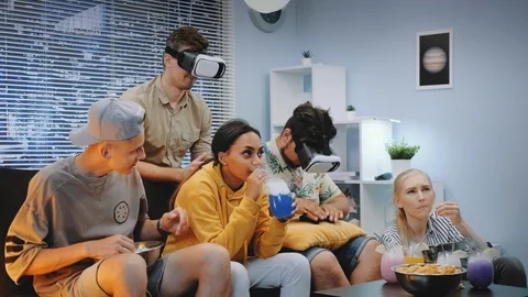 Two young men playing online game in virtual reality glasses, one guy wins the Video stock 112579643