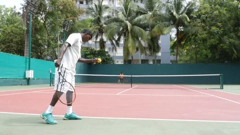 Two  young men playing tennis/match on a hard court  Stock Footage 92573394
