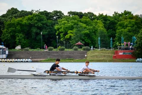 Two young men rowing a double scull boat on Ada Ciganlija lake in Belgrade,.. Stock Photos