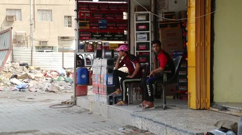 Two Young Men Sitting in Front of Shop Waiting for Customers Vidéo 42957965